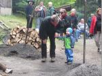 Köhler Gerd Schramm zeigt dem jüngsten Besucher den Kohlenmeiler